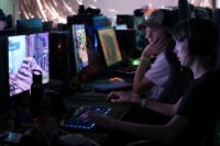 Två ungdomar sitter och spelar på ett LAN.
